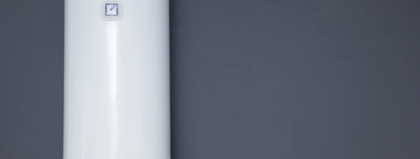 Boiler moderno instalada em parede de cor cinza escuro, para aquecimento de água residencial ou comercial, com controle digital.