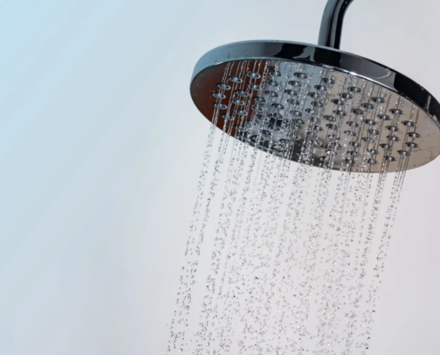 Chuveiro moderno com água fluindo em gotas claras contra fundo azul e branco