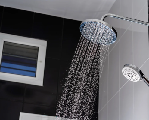 Chuveiro moderno com água corrente em banheiro com azulejos pretos e brancos