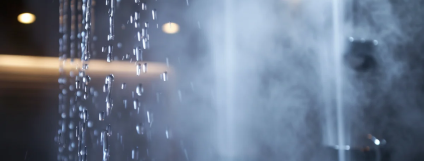 Chuveiro com água quente e vapor em banheiro moderno