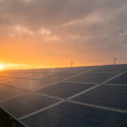 Painéis solares captando energia durante o pôr do sol em campo aberto