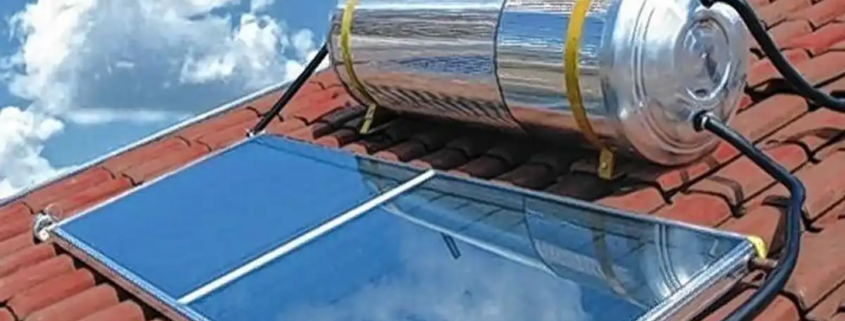 Sistema de aquecimento solar instalado em telhado de casa, com painel solar e cilindro de armazenamento, aproveitando energia solar para aquecimento de água.