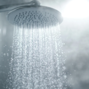 Chuveiro com água quente e vapor no banheiro