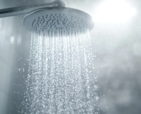Chuveiro com água quente e vapor no banheiro