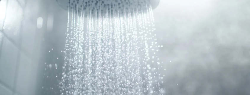 Chuveiro com água quente e vapor no banheiro
